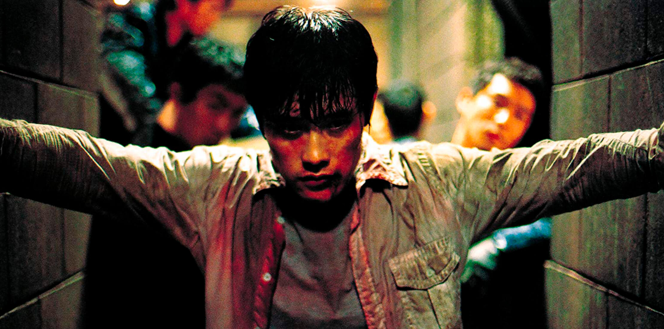 Shot from the film, depicting Sun-woo (Byung-hun Lee) standing bloodied and battered in a dark corridor