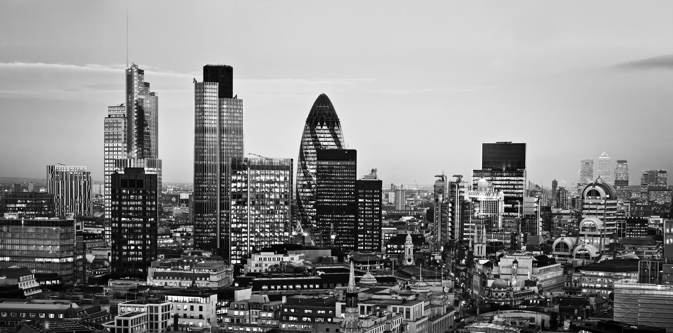 Black and white image of a cityscape of London, including the Gherkin, Tower 42 and Canary Wharf