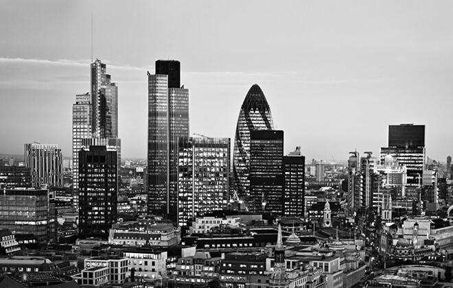 Black and white image of a cityscape of London, including the Gherkin, Tower 42 and Canary Wharf