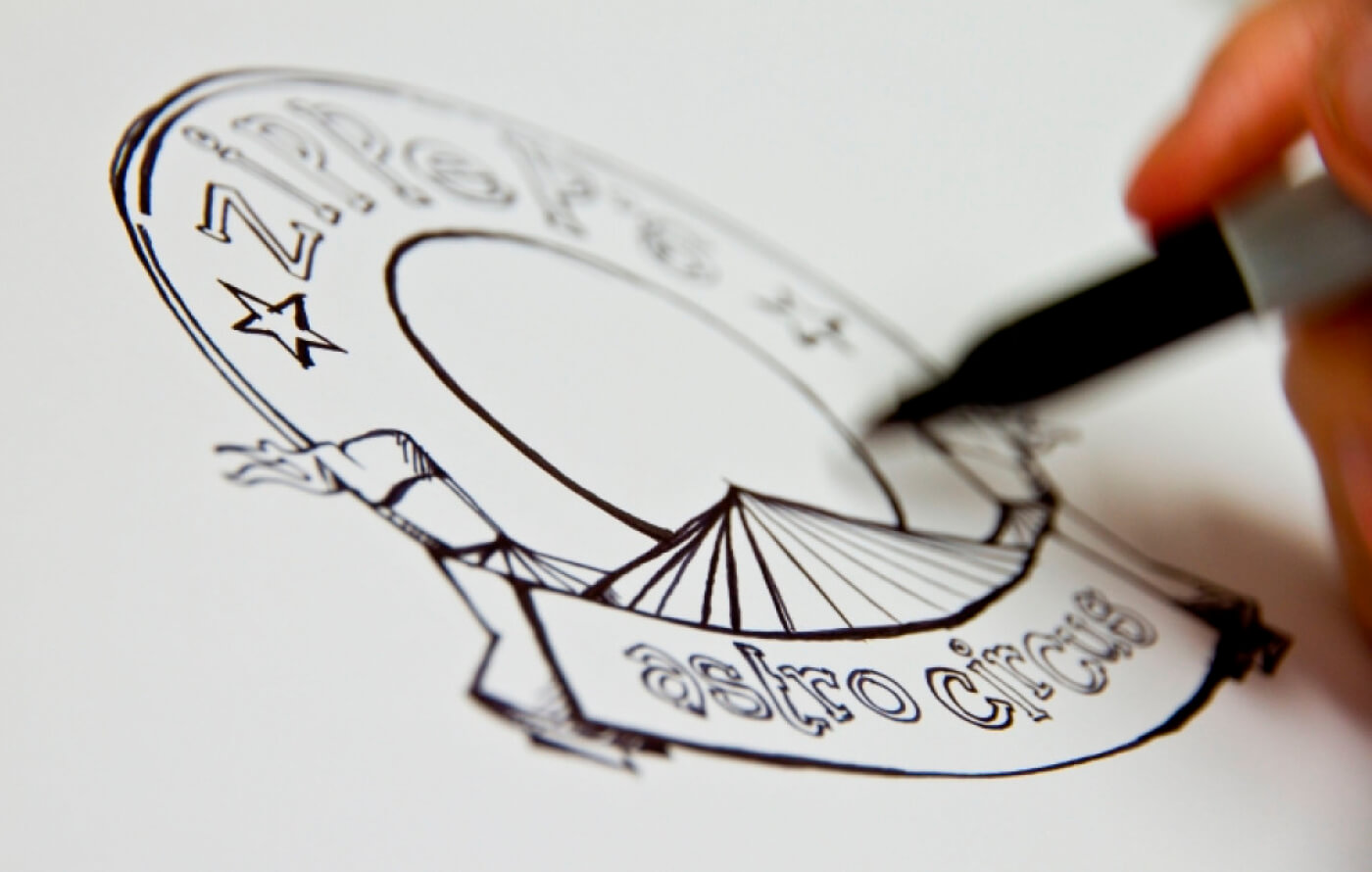 Early black and white sketches of the main Astro Circus logo, drawn using a black felt tip pen
