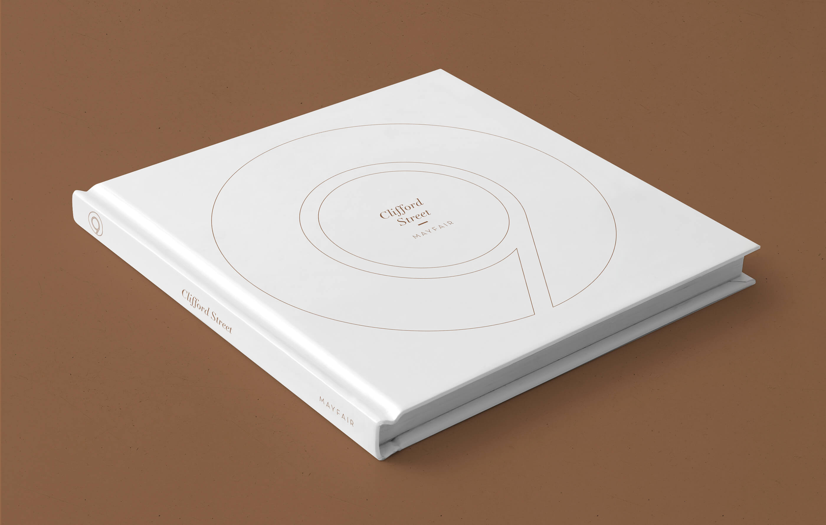 White square hardback brochure for Savills and Cushman & Wakefield, on a dark gold background