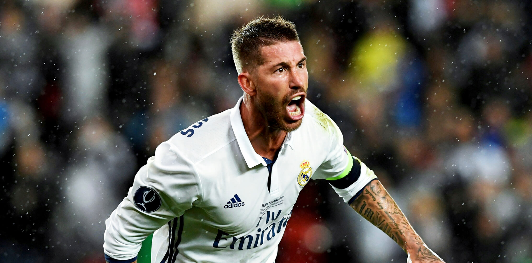 Real Madrid footballer Sergio Ramos wearing a white football shirt and captain's armband, celebrating after scoring a goal