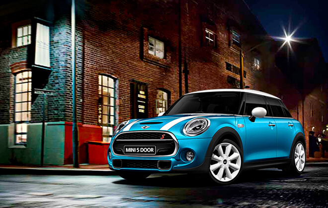 Blue 5 door Mini Cooper on a street at night