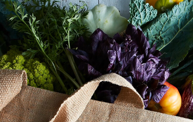 Closely cropped photo of fruit and vegetables on a rustic blue wooden table